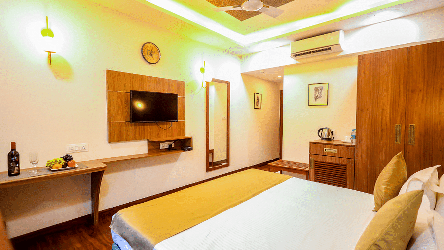 Deluxe room with bed and televison mounted on the wall at Vagator Downtown, Goa 