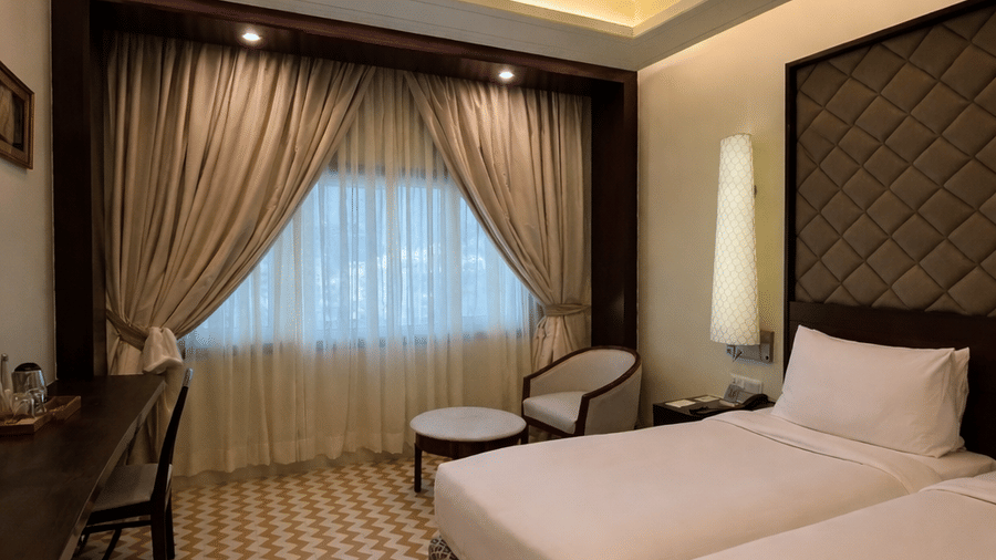 The Superior Twin room at Clarks Amer, Jaipur displays twin beds, zigzag patterned flooring, and a desk area.