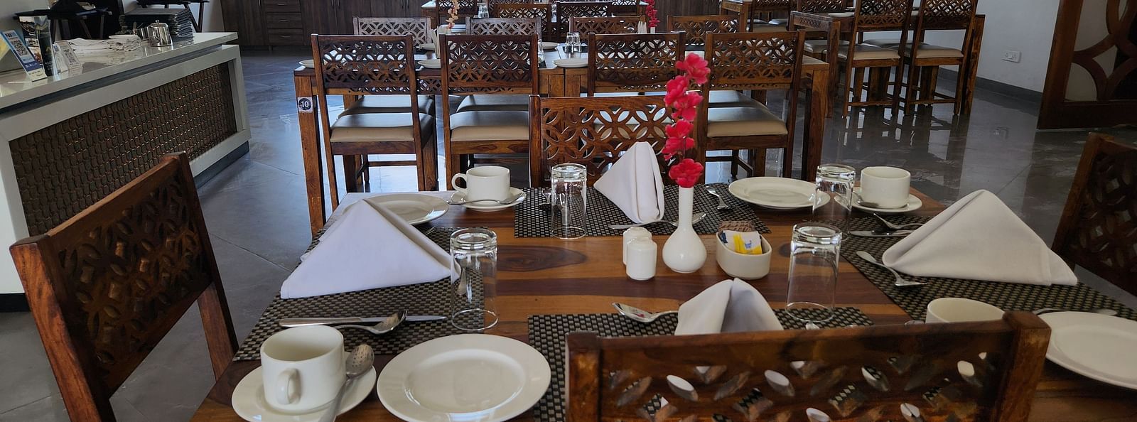 An indoor dining table is neatly set with plates, cutlery, and napkins, ready for a meal - Bamboo Saa Mulberry Resort, Pushkar