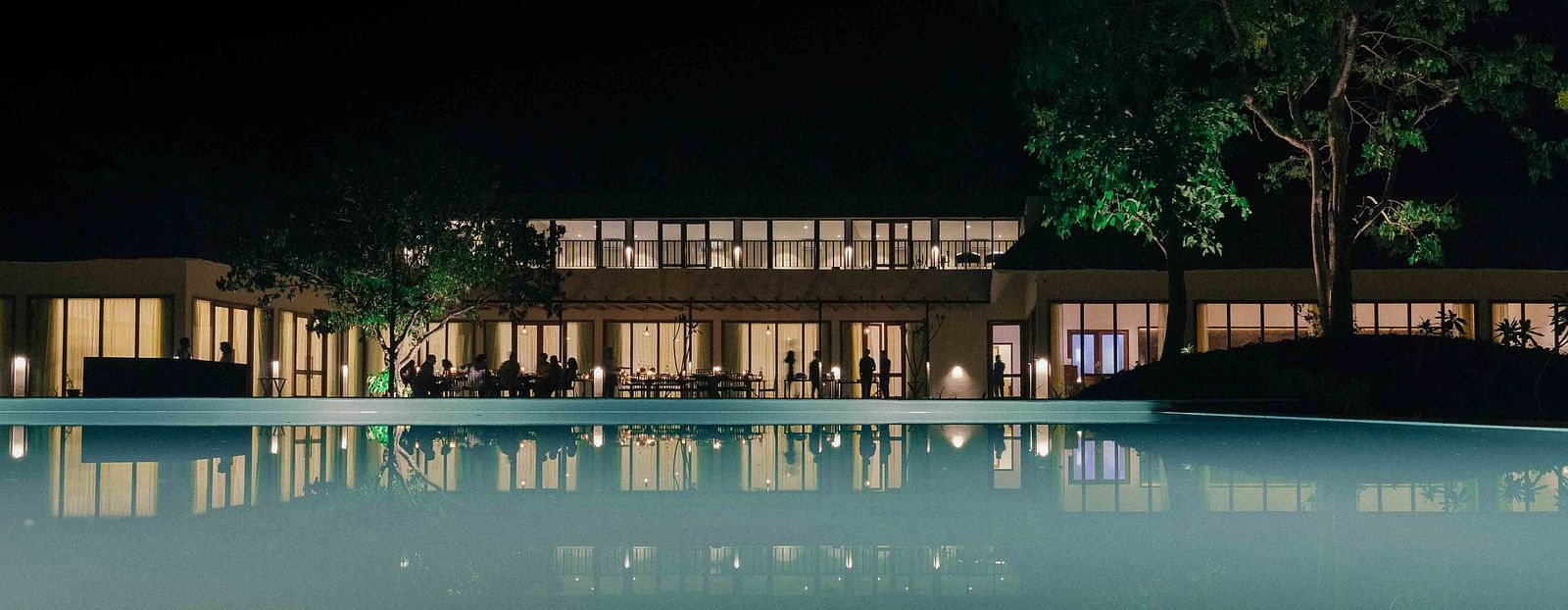 facade of Saraca Corbett with a pool in front of it during night time