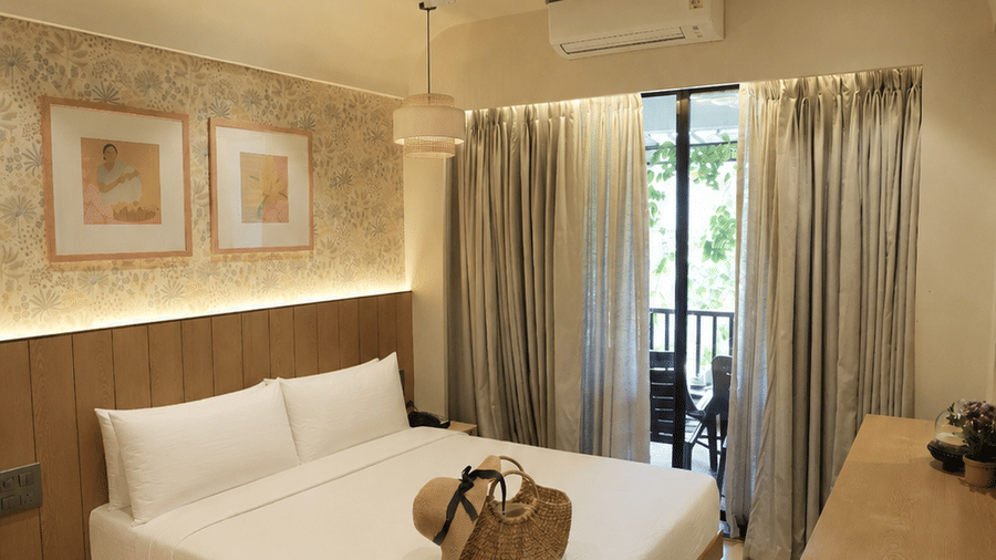 A queen size bed, wall arts, and a balcony at Bougainvillea, Alibaug.