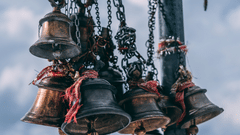 Temple bells with red sacred thread surrounding them