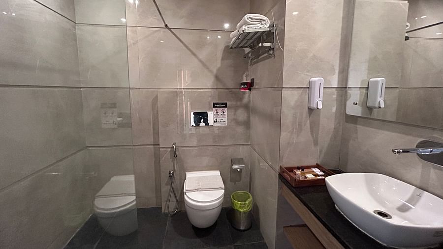 The washroom of a premium room with wash basin, and toilet seat - DLS Grand Luxotica, Dehradun