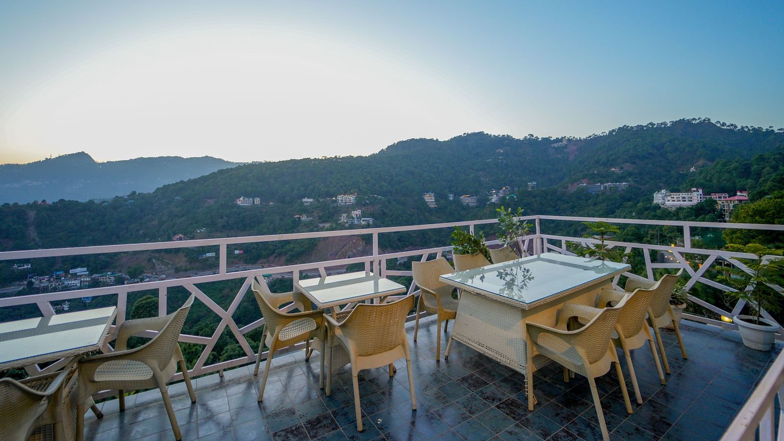 An image featuring the view of mountains from the terrace with chairs and tables - DLS Whispering Winds
