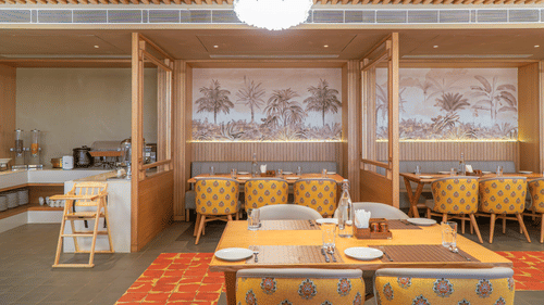 The restaurant at Pride Elite Himmatnagar boasts sleek wooden frames and an elegant dining atmosphere.