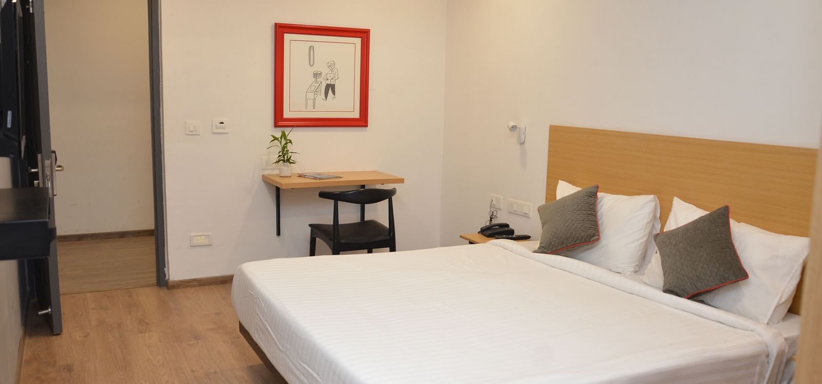 Corner view of a bedroom with a double bed, wardrobe, and bedside table - Lords Eco Inn Belagavi