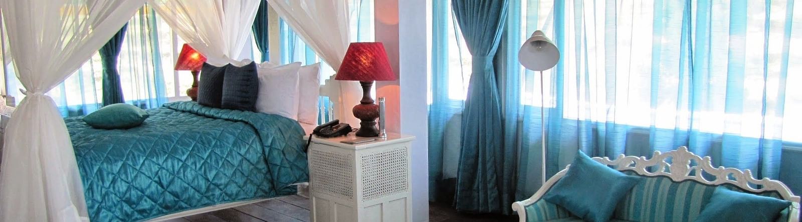 Room with bed and sitting area with sofa at Bed with side canopy and a lamp on the side of the bed at 3 bhk cottage at Te Aroha by Shervani Mukteshwar