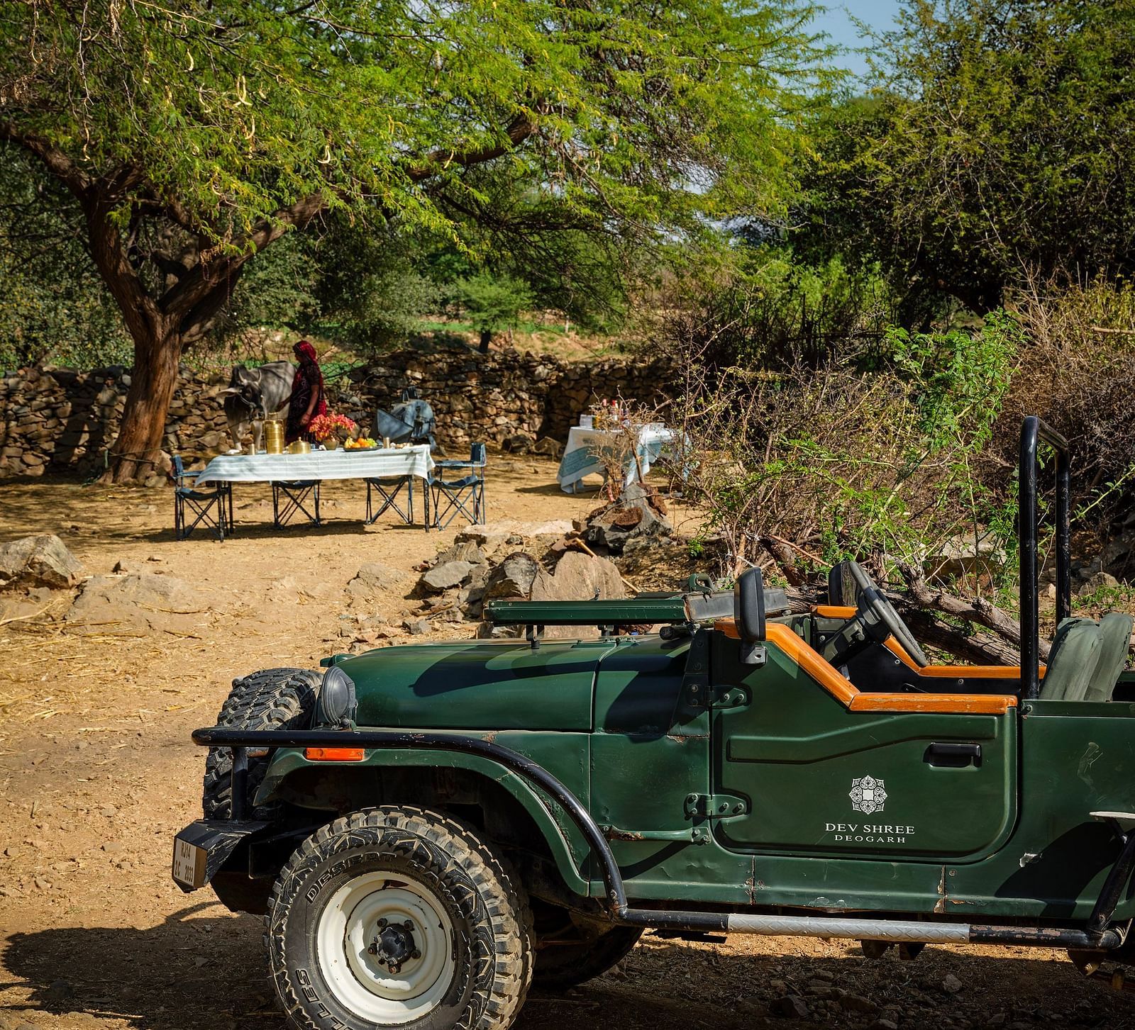 image of a green coloured safari jeep parked on a dry land