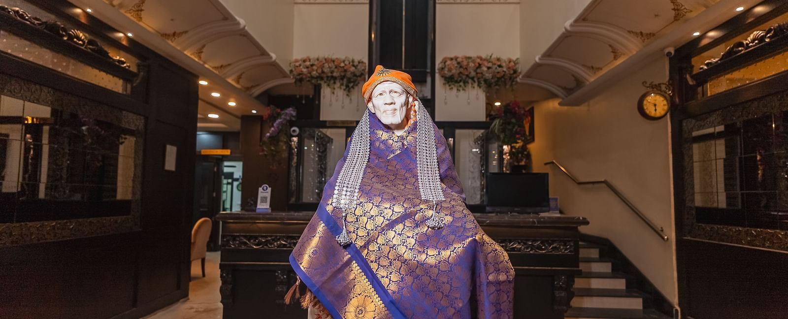 The statue of Sai Baba draped in fabric is positioned in the lobby at Hotel Ashok Nagpur.