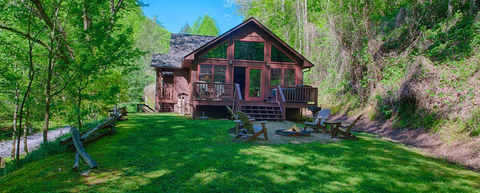 facade image of wooden cabin with a lush green lawn in front of it - Historic Tapoco Lodge