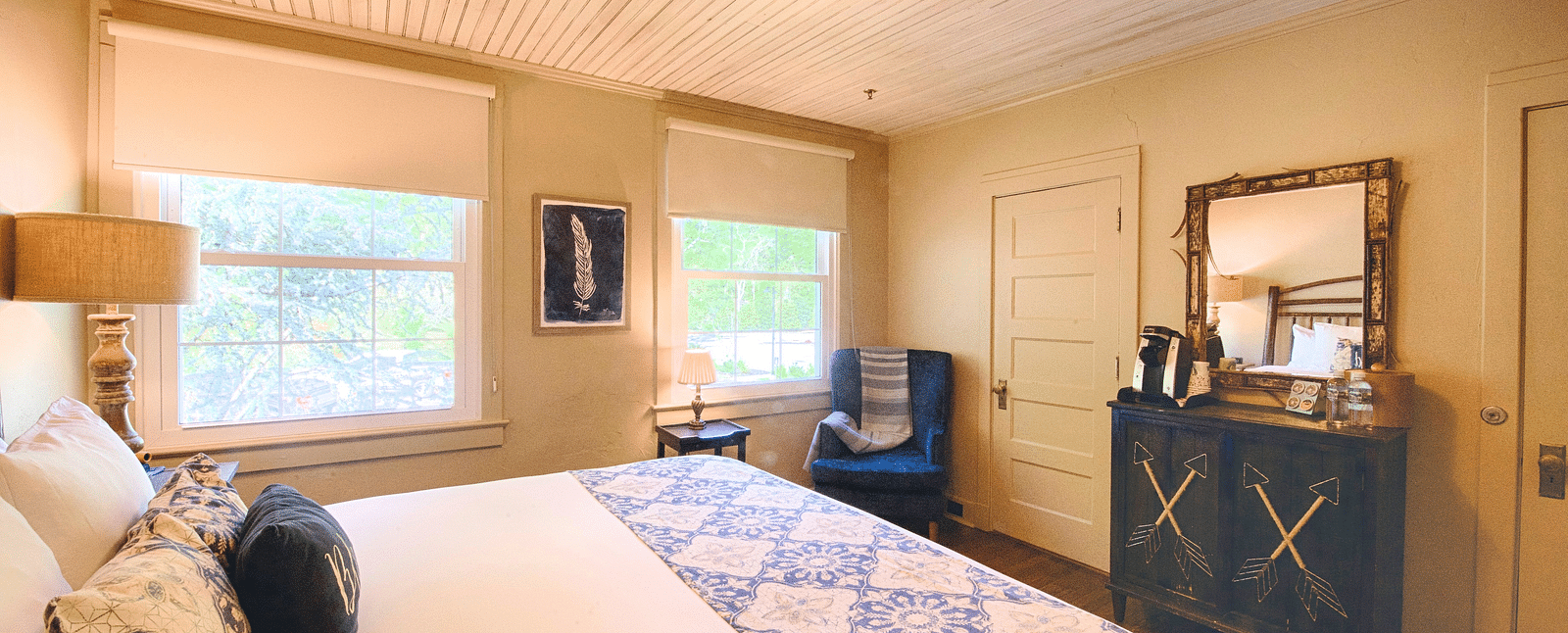 full view image of a cozy bedroom with a comfortable double bed and a wooden cabinet along with a mirror above it - Historic Tapoco Lodge