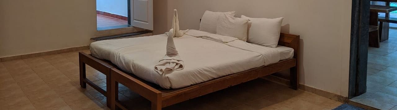 A bedroom with a minimalist design and a bed at The Conservancy Bungalow.