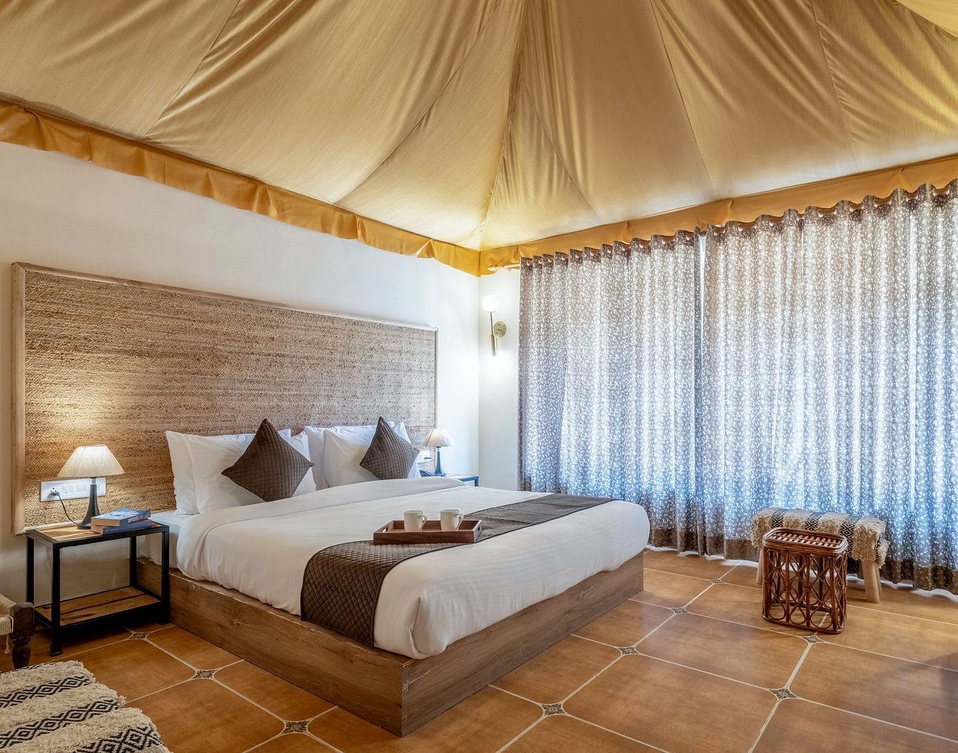 A tent accommodation at Valley by Grassfield with a bed and a light hanging from the ceiling.