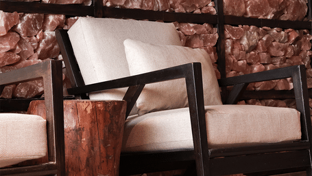 armchair seating inside a cozy spa relaxation room with a textured salt brick feature wall at Kavya Himalayas.