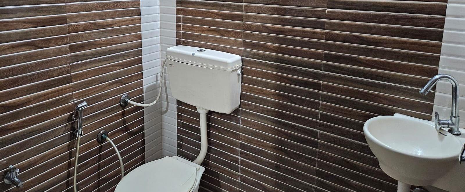 The bathroom at the Dream Vision Guest House featuring a commode and a wash basin.