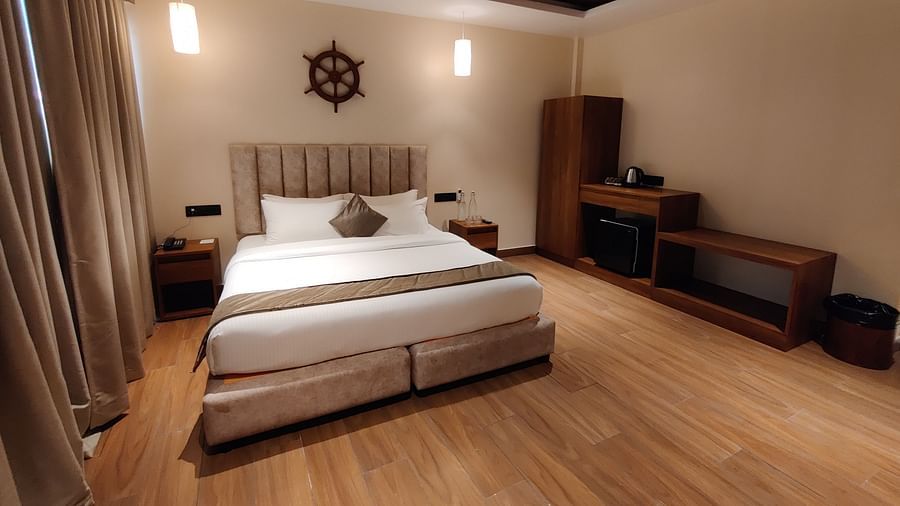 Side view of the room showcasing the veranda with sliding glass doors and greenery