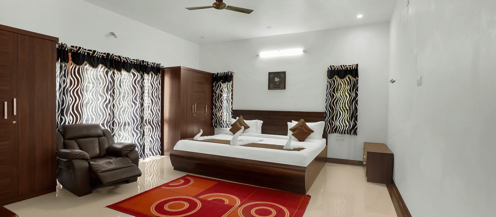 A spacious bedroom with a large bed and wooden furnishings at WOW Bungalow, Yercaud.