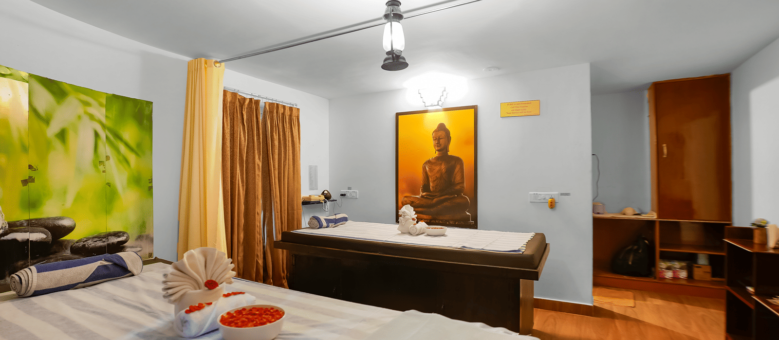 Spa room with two massage beds and a decorative wall mural at WOW Bungalow, Yercaud. 