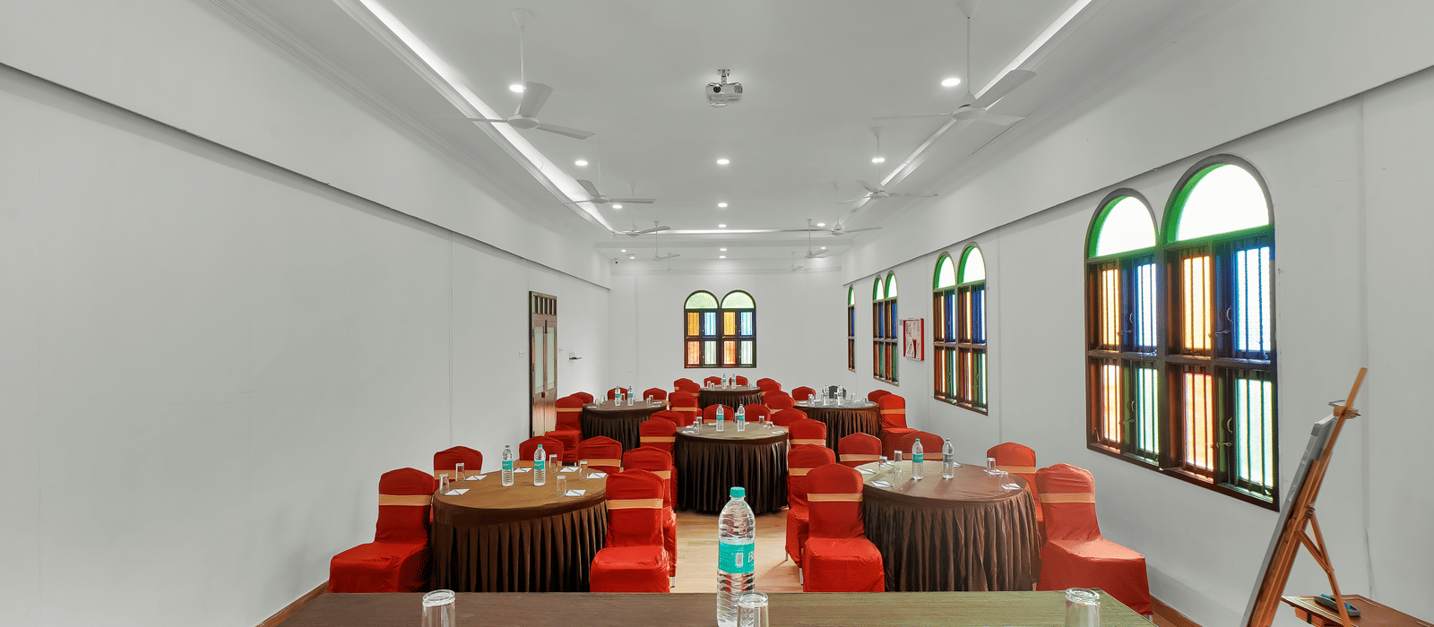 View from the front of the banquet hall with chairs arranged around the round table at WOW Bungalow, Yercaud.
