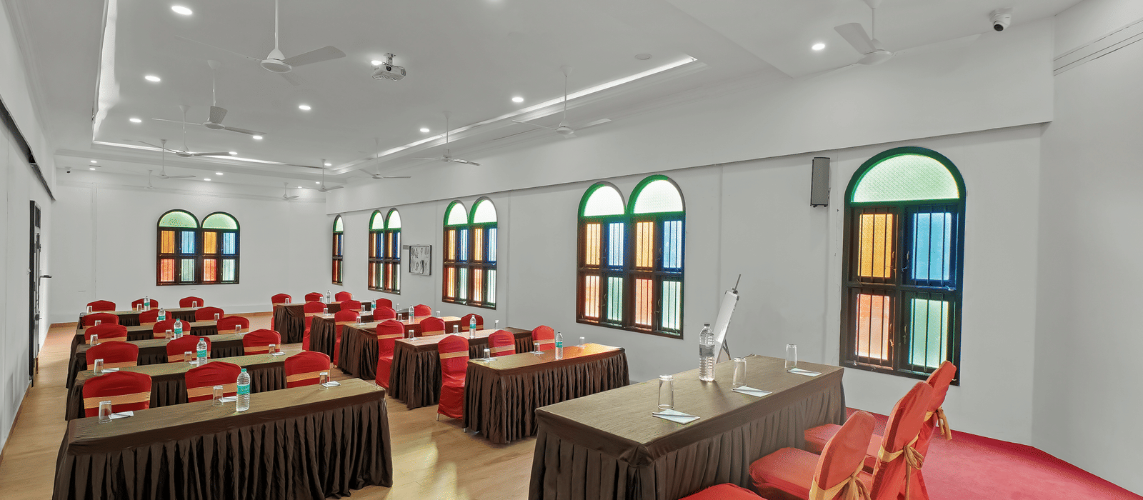 Diagonal view of a banquet hall with tables and chairs arranged for an event at WOW Bungalow, Yercaud.