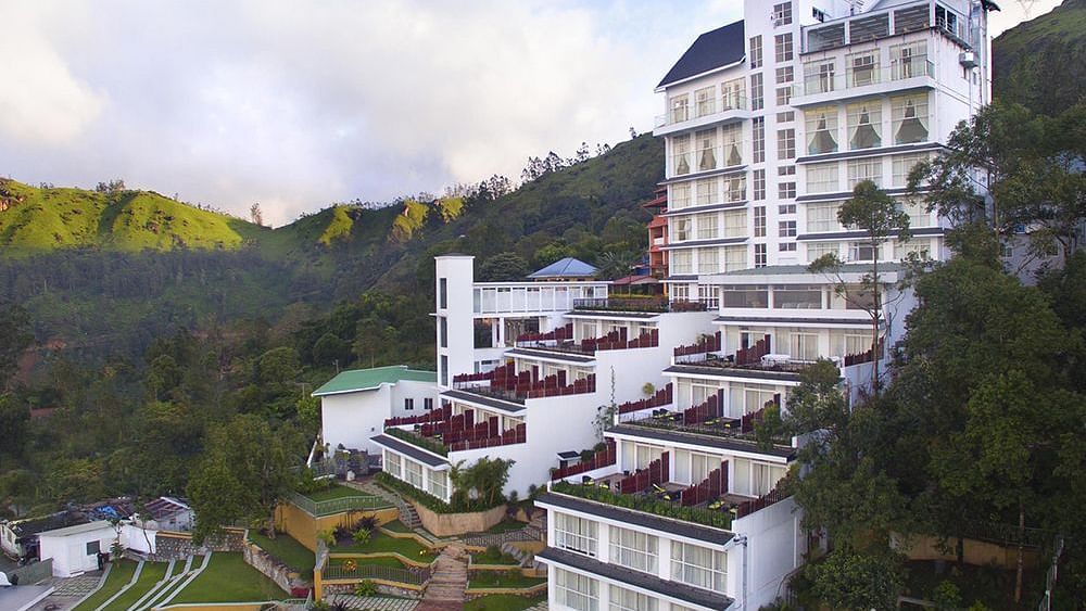 Facade view of Fragrant Nature Munnar, surrounded by majestic mountains