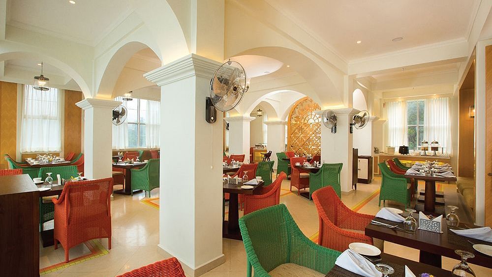 Multi-cuisine restaurant with a warm ambience and tables set ready at Fragrant Nature Munnar