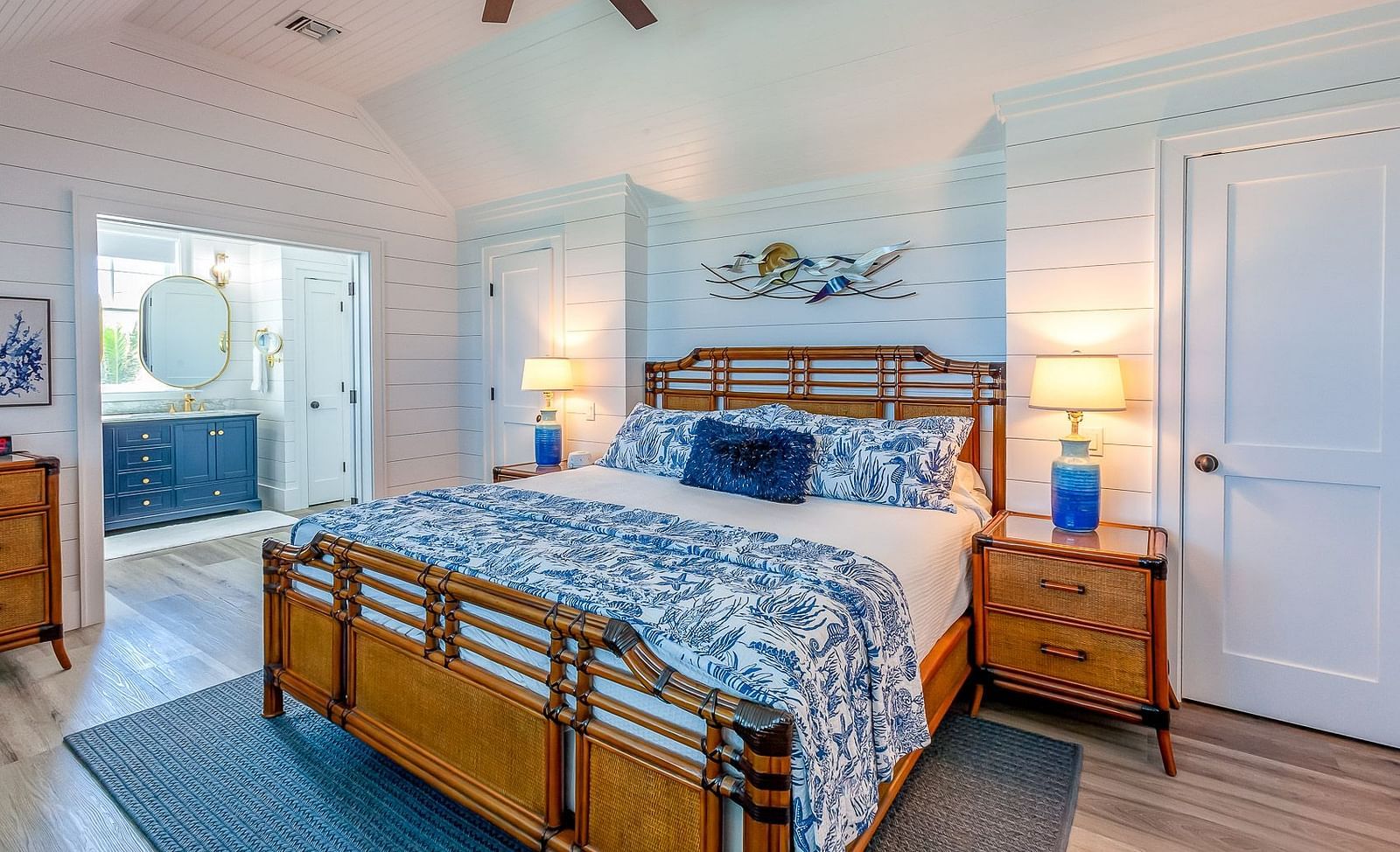 Bedroom with a wooden bed frame, blue bedding, and white coastal decor | Abaco Inn