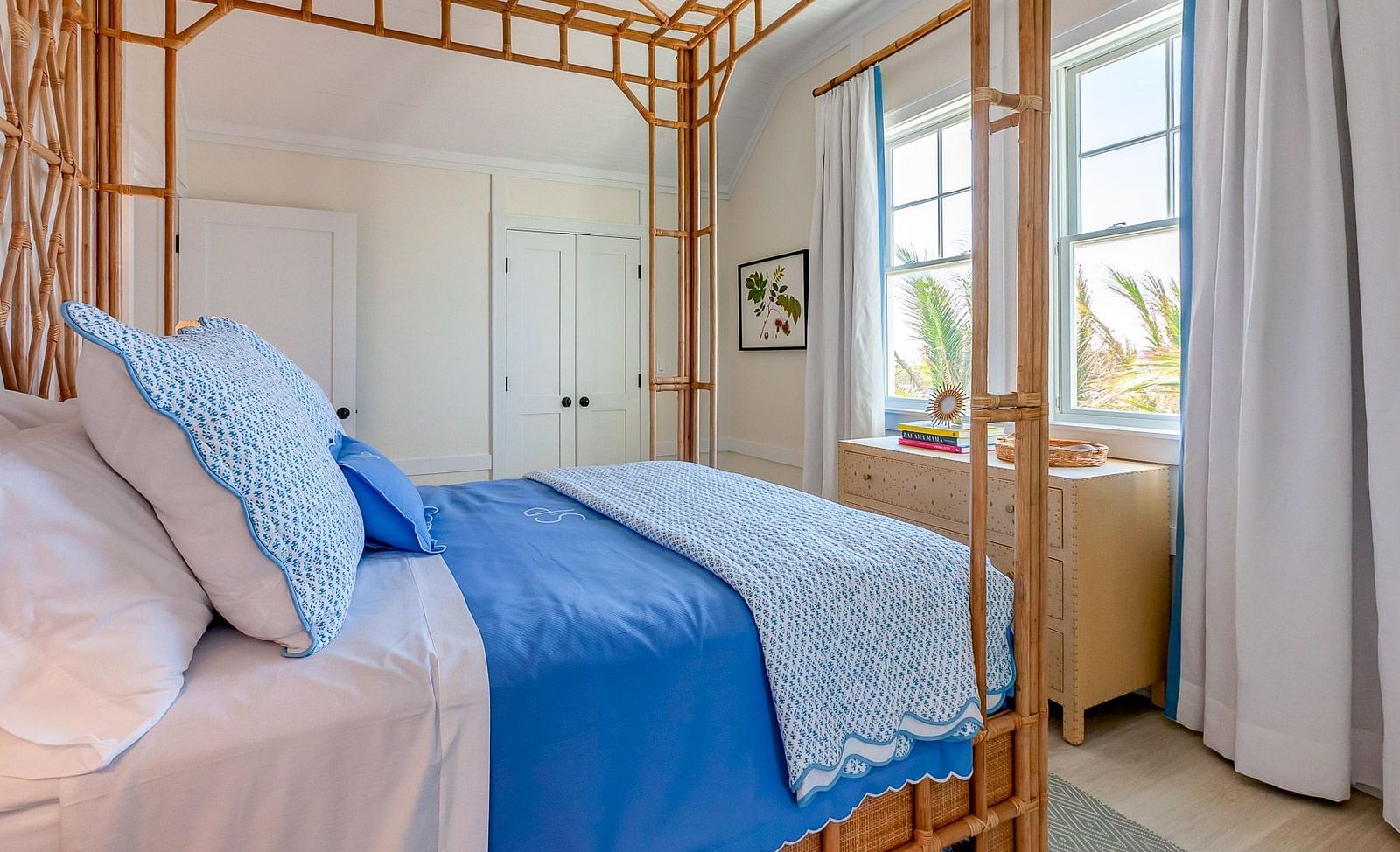 Bedroom with a bamboo four-poster bed, white and blue bedding, and soft natural lighting | Abaco Inn
