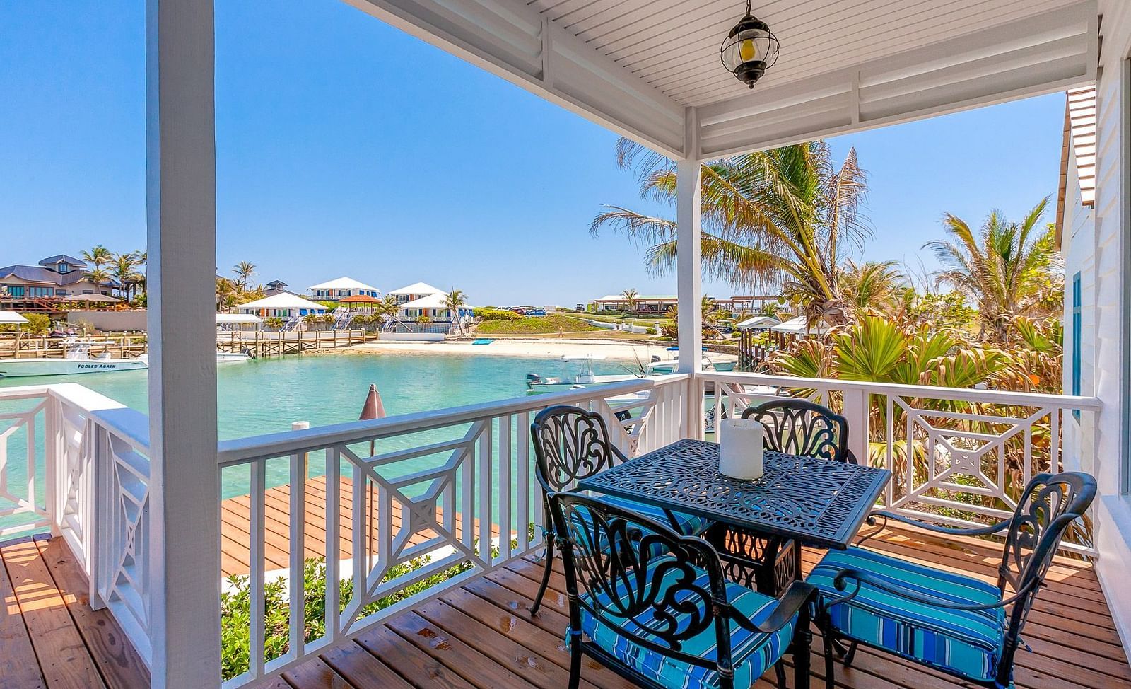 Outdoor dining table on a covered balcony with waterfront views | Abaco Inn