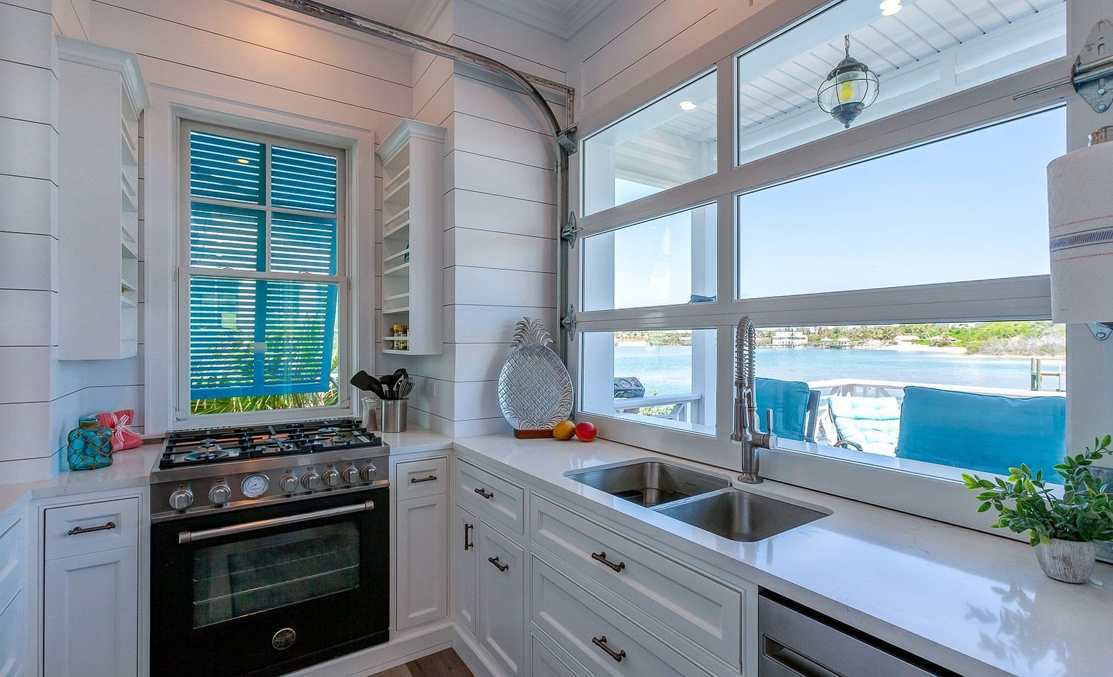 Modern kitchen with white cabinets, stainless steel oven, and large windows | Abaco Inn