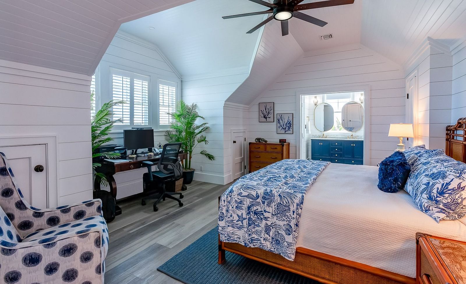 Spacious bedroom with a wooden bed, blue accents, and a ceiling fan | Abaco Inn
