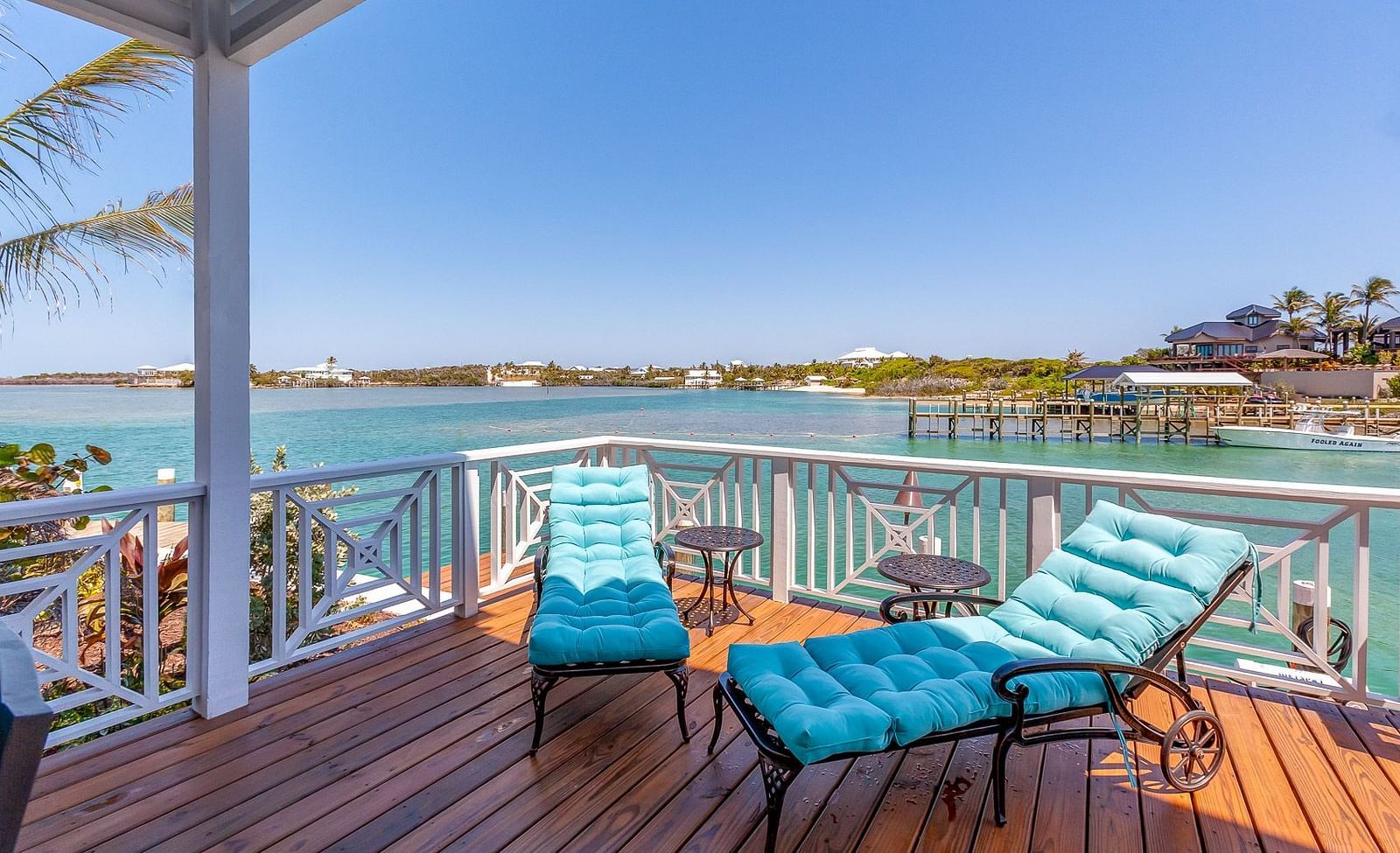 Wooden deck with blue sun loungers overlooking the water | Abaco Inn