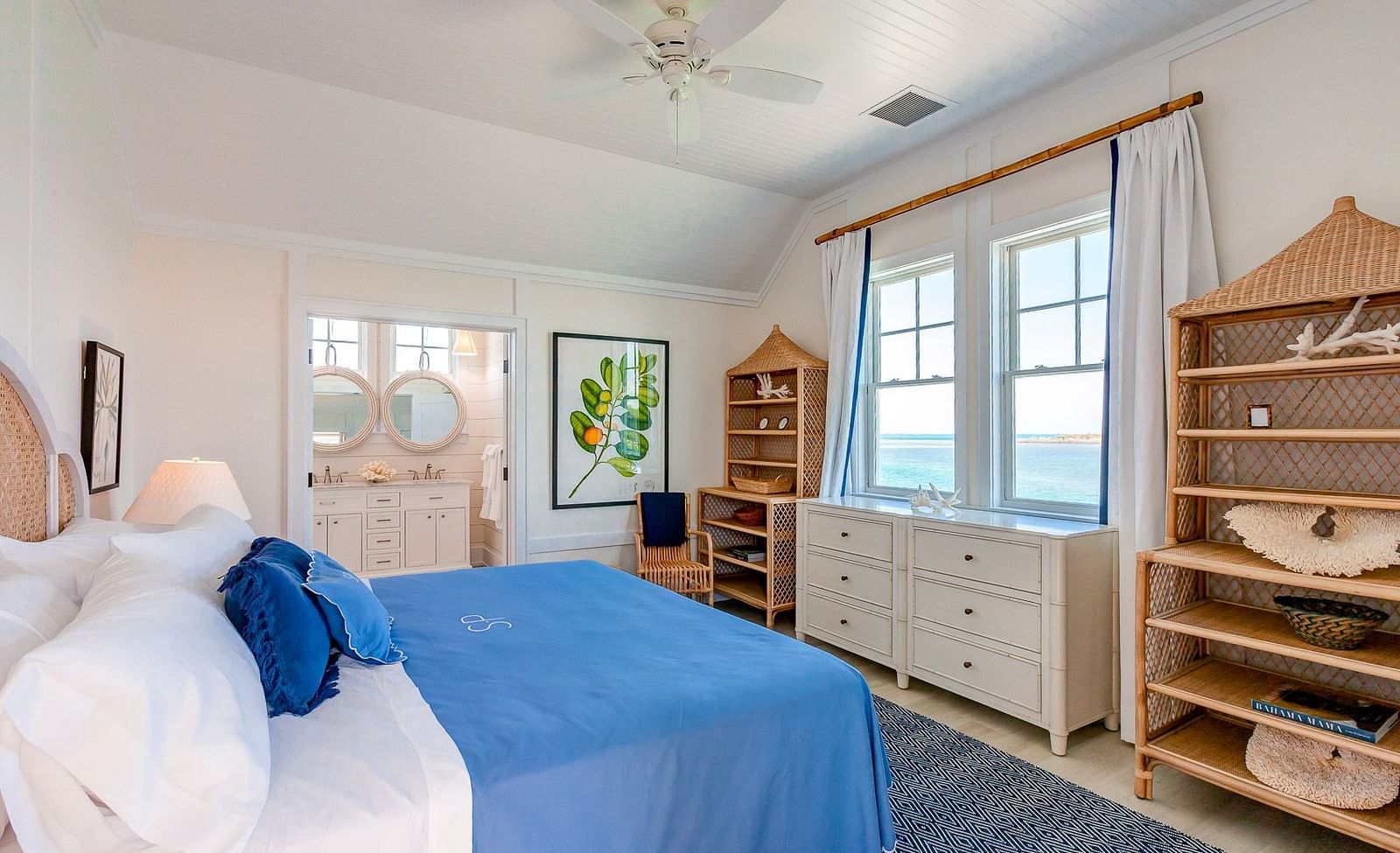 Bedroom with a blue bedspread, wooden shelving, and a ceiling fan, featuring a cozy coastal aesthetic | Abaco Inn