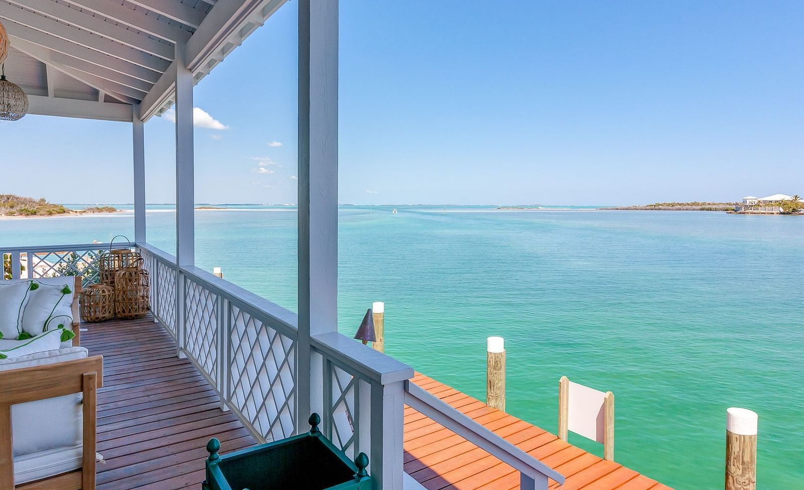 Wooden deck overlooking turquoise waters with chairs and a table under a covered porch | Abaco Inn