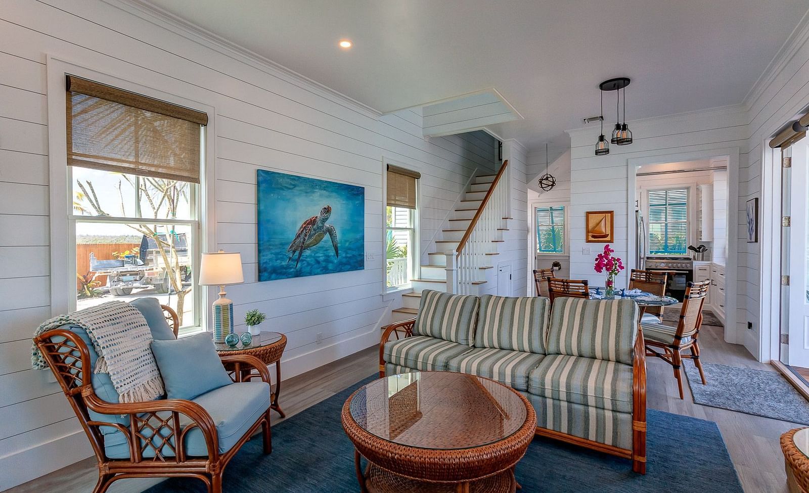 Bright living room with striped sofa, wooden coffee table, and coastal décor | Abaco Inn