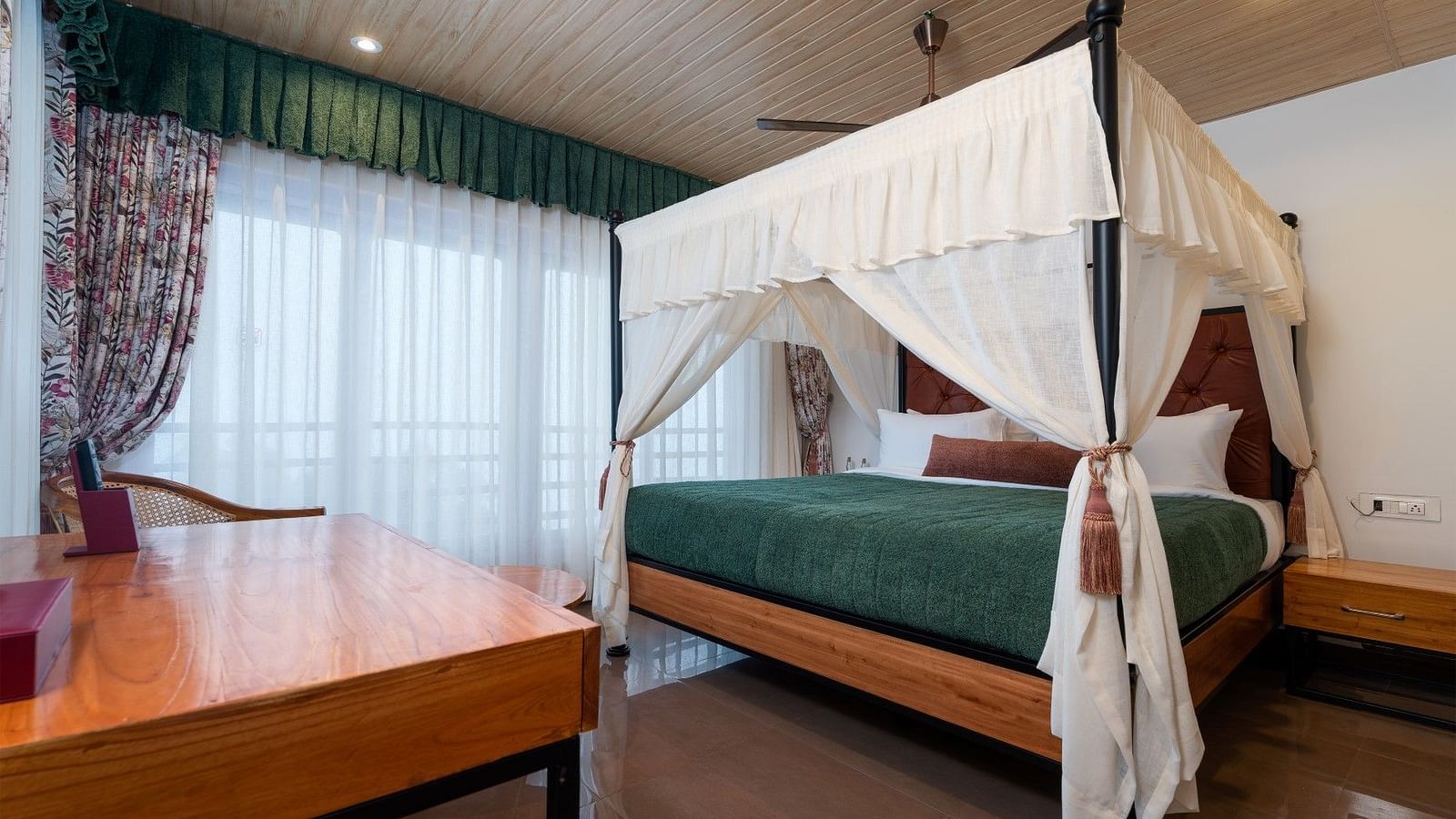 A spacious bed with ample lighting, complemented by wooden furniture.