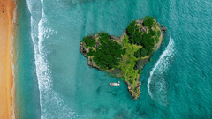 an aerial view of a heart-shaped island near a beach with water overlapping on it