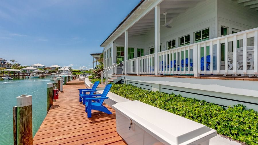 Blue chairs on the dock facing the ocean | Abaco Inn