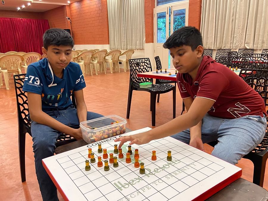 kids playing chess inside the game room at Ibex River Resort, Pollachi