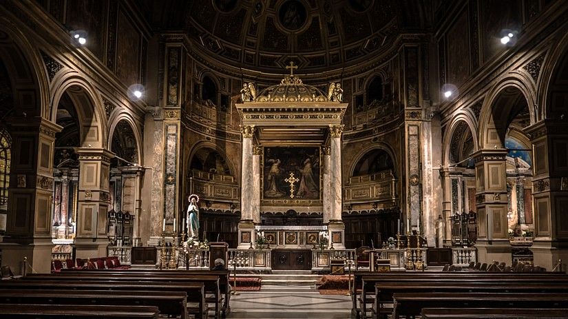 Interior of a church with lights on and the diaz in the background