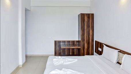 A  spacious room with a bed and wardrobe at La Vida Studio Inn Goa.