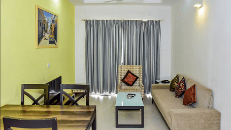 Living and dining space with a sofa and table at La Vida Studio Inn Goa.