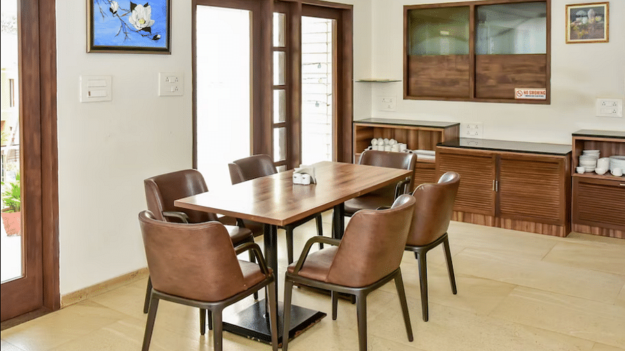Dining area with a wooden table and chairs, part of the inn's interior at La Vida Studio Inn Goa.