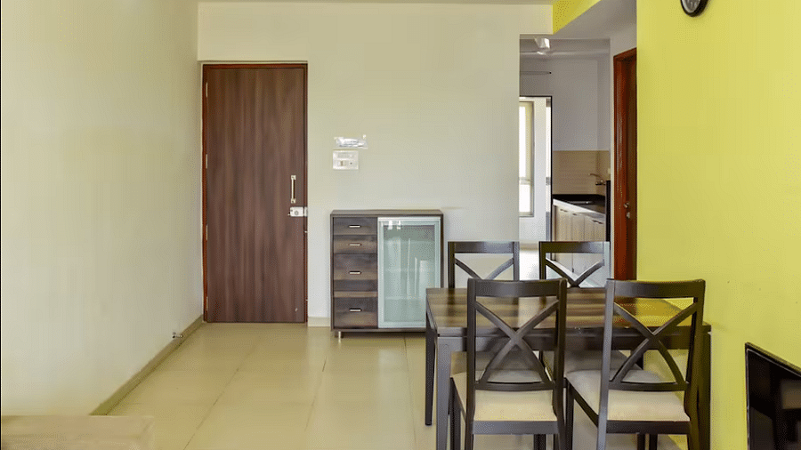 Dining area with a table and chairs, a door way leading to another room at La Vida Studio Inn Goa.