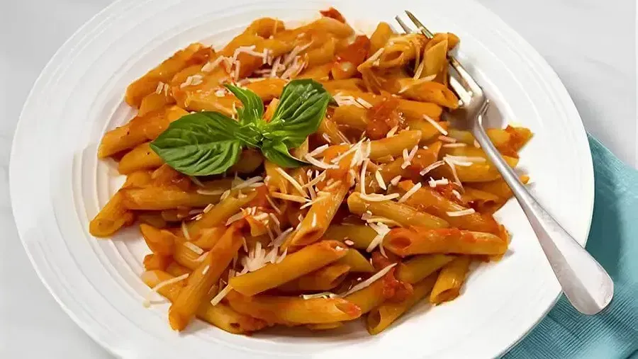 A dish of pasta placed on a white surface at Indie Stays Resort, Goa.