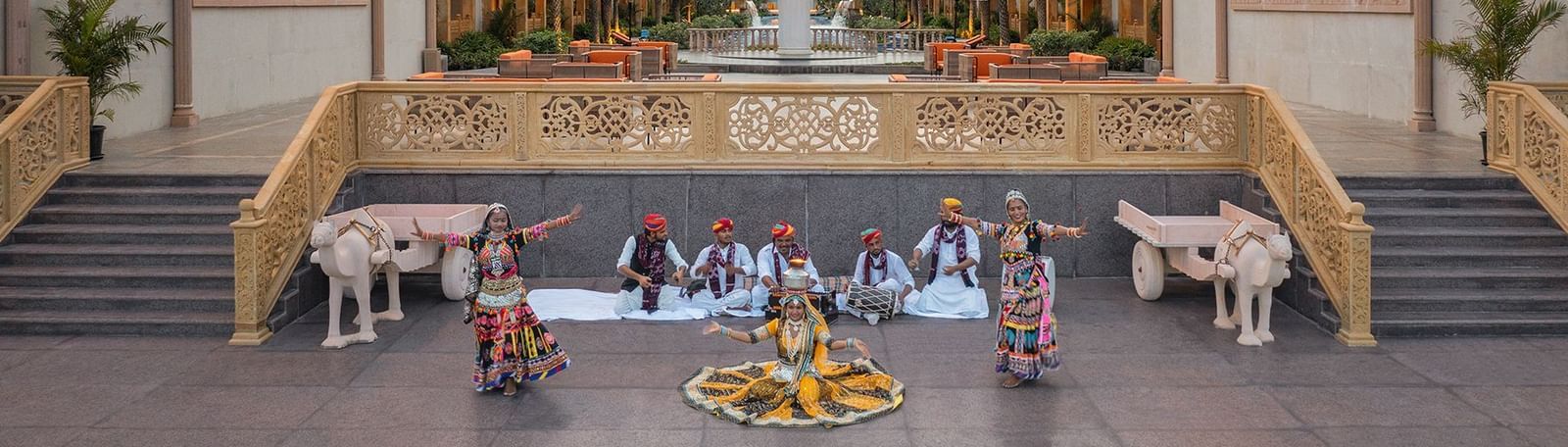 Two women performing the traditional rajasthani dance with musician playing instruments behind them - Kaldan Samudhra Palace
