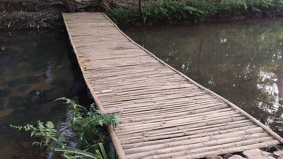 A simple wooden bridge over a river-Amanvana Spa Resort, Coorg - Luxury Resort