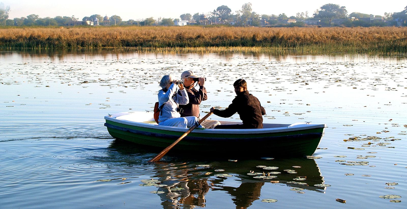 Three people sitting in a boat- Shahpura Bagh.