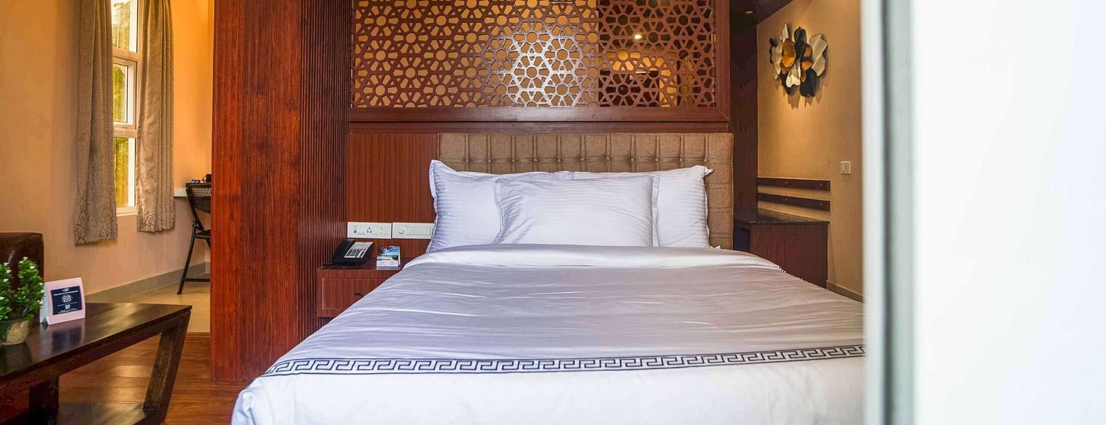 A comfortable and stylish bedroom at Mansha Palace features warm lighting and wooden accents.