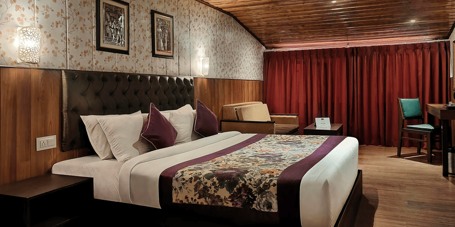 Elegant double bedroom with plush bedding and classic décor at Mount Thistle Boutique Hotel, Darjeeling.